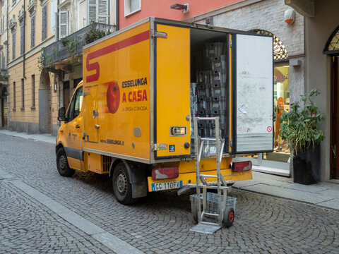 Yellow Esselunga home grocery delivery van parked on cobblestone street in Italian city center