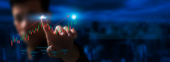 A person is using their finger to touch the stock market graph, which is showing upward trend, as they navigate the complex world of financial analysis and decision-making.