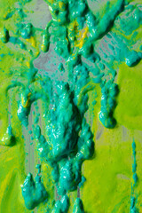 Bright green and yellow paint splashes cover the surface. The paint is thick and has a glossy...