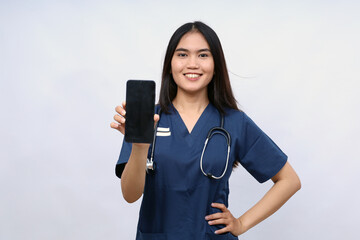 Smiling young Asian woman nurse working wearing a blue uniform showing smartphone with blank screen...