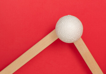Still life with wooden blocks and a a plastic foam ball on red background	