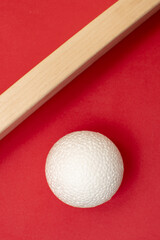 Still life with wooden blocks and a a plastic foam ball on red background	