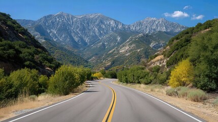 Fototapeta premium The winding road through the mountains stretches into the distance, offering a perfect setting for a road trip, with breathtaking views along the way. 