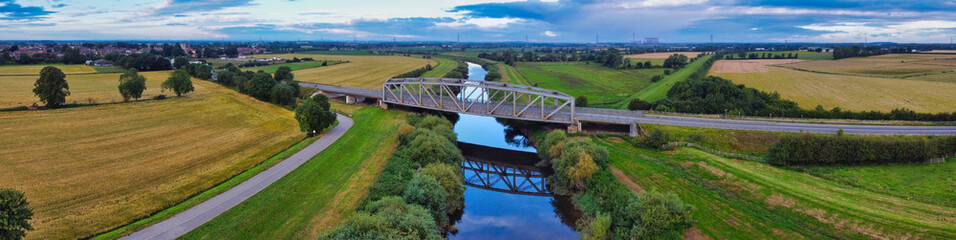 Fototapeta premium Aerial panorama view of old iron bridge crossing River Aire