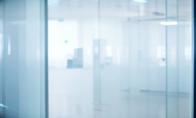 Blurred interior view through glass walls depicting a modern office space.