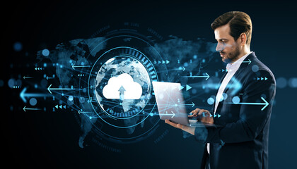Businessman using laptop for cloud computing with digital data transfer interface on futuristic world map background in blue light concept.