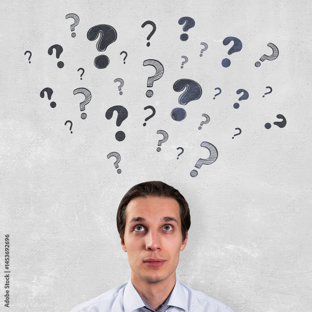 Poster Thoughtful businessman standing against light wall background with question marks symbolizing confusion and decision-making process.