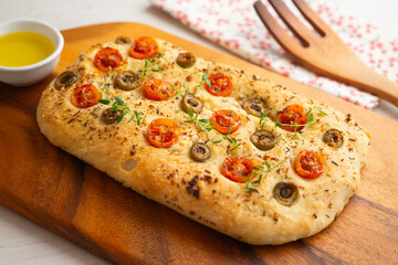 Authentic Italian focaccia with tomatoes and green olives.