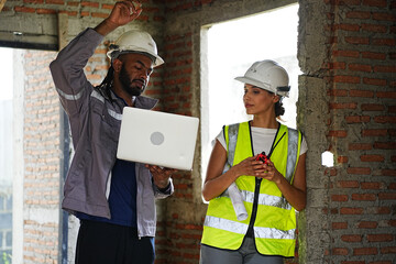 Construction workers on site inspecting house residential building project. Diverse people wear safety hard hat examining concrete built structure in property development business. Civil engineering.