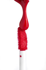 Red drop liquid lipstick falls on applicator. Closeup shot of colorful brush liquid lipstick