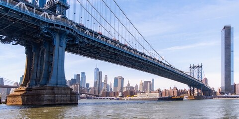 Obraz premium Cars driving across Manhattan Bridge on a sunny day with Lower Manhattan skyline in background