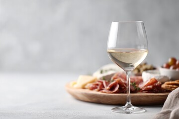 minimalist shot of neatly arranged charcuterie board with glass of wine blurred figures in background