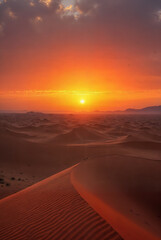 Sunset over the sand dunes in the desert. Landscape of the desert