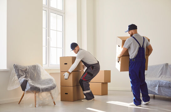 Delivery service men carrying, shipping specialists for transporting, cardboard boxes, movers service unloading and removing things for moving company working, helping to change residence packing