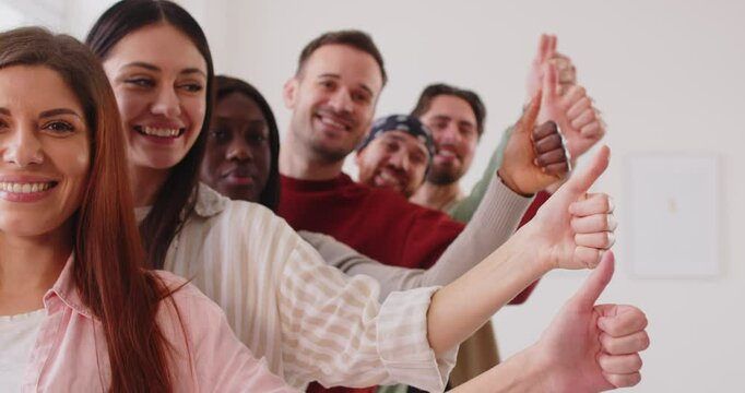 Happy multiethnic people standing in row and making thumb up gesture as recommend something of good quality, look glaadfully and say we approve this, nice choice, sharing positive feedback