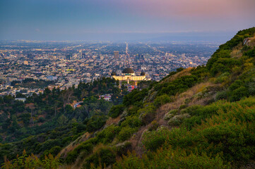 Obraz premium Sunset view of the lit-up Griffith Observatory with Hollywood and the Los Angeles cityscape in the background.