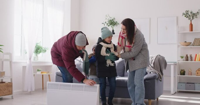 Extremely cold home, unhappy badly frozen family in freezing cooled flat wearing warm coats, shivering tremble with cold, feels bad problem, climate, temperature regulation, no central heating