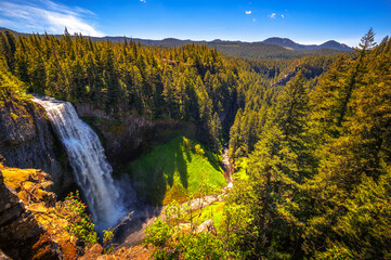 Wide view of Salt Creek Falls surrounded by dense forest in the Cascade Range, Oregon, USA. It is the second highest waterfall in Oregon, with a drop of 286 feet.