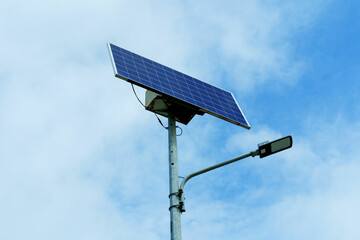 Obraz premium Solar-powered streetlight mounted on a tall metal pole and tilted slightly upward to maximize sunlight absorption. The concept of the integration of solar energy in everyday infrastructure 