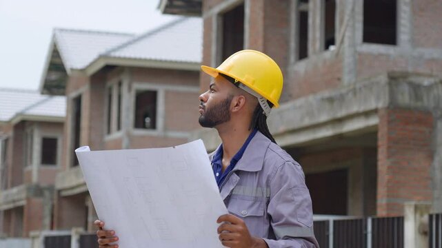 Black construction workers look at construction plans and operations to ensure they meet construction standards.