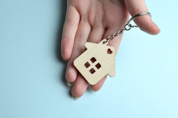 Keychain in the shape of a house in the palm of your hand. Close-up.