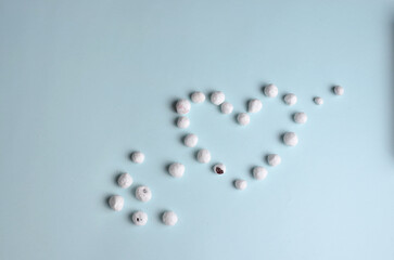 On a blue background, a heart of cranberries in sugar.