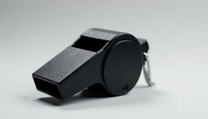 Classic black plastic whistle, textured surface, front view, referee, blow