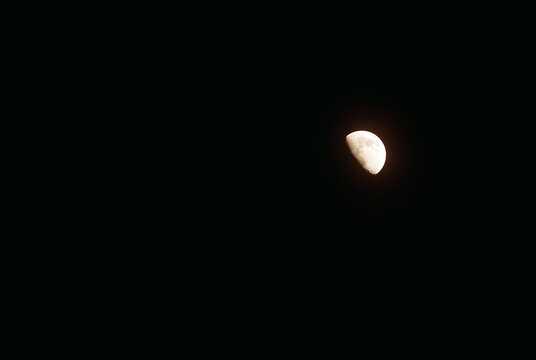 Bright waxing gibbous moon floating on night sky