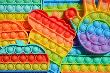 Bright multi-colored pop-its, children's silicone anti-stress toys, with hemispheres for pressing. Top view, background