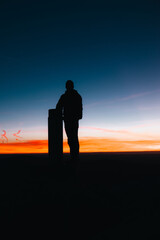 Silueta de hombre en la cima de la montaña al amanecer