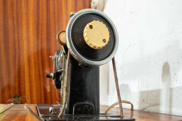 Vintage sewing machine viewed from behind, showing aged metal and mechanical parts. Captures retro industrial design and nostalgia of traditional garment production.