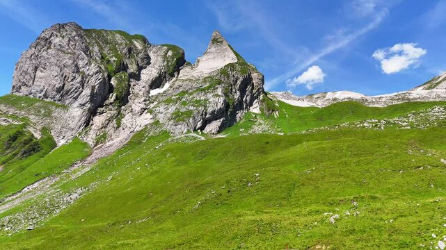 9 juli 2024, Wildhaus, Switzerland. Forward Drone flight, in Alpstein mountains. Fresh green meadow, with stunning rocky mountain peak during summer. Wonderful Alpstein.
