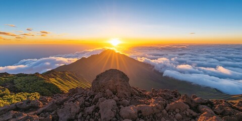 Sunrise over mountain with cloud cover, view from rocky terrain