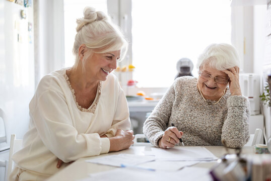 Woman helping her elderly mother preparing financial documents
