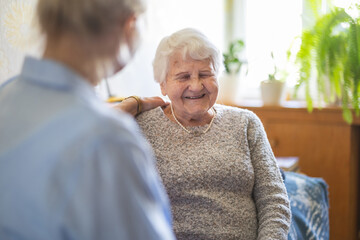Female home caregiver providing emotional support to an elderly woman
