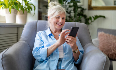 Senior woman using mobile phone at home
