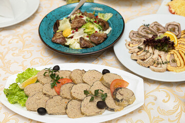 restaurant dish - stuffed fish with an orange slice and a hot salad with red meat