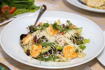 Arugula and shrimp salad on a white plate