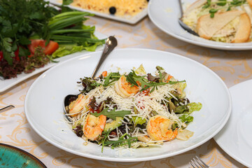 Arugula and shrimp salad on a white plate