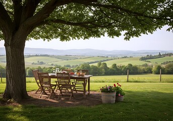 A charming outdoor dining setup under a large tree, overlooking rolling hills and green fields, with blooming flowers adding a splash of color