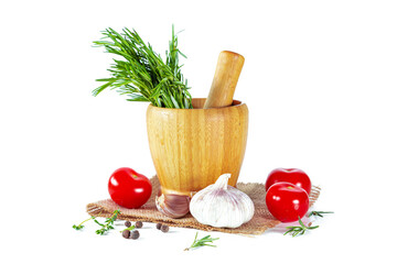 Wooden mortar with fresh herbs, garlic, peppercorns and tomatoes.