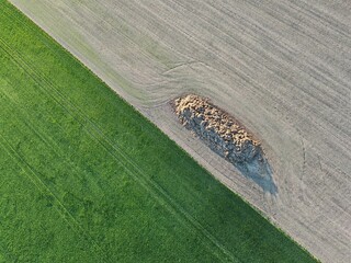 Aerial view of manure pile on edge of field and meadow, representing ecological agriculture and...