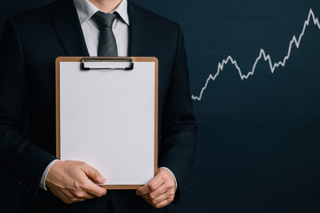 Business strategy insights man holding clipboard financial growth graph professional attire modern office atmosphere