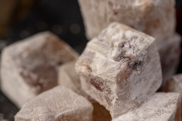 cubes of Turkish delight with the addition of dried berries in powdered sugar closeup