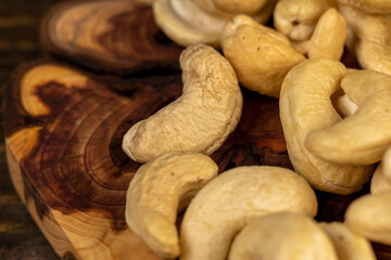 cashew are scattered on a board, cashew are healthy and allowed for vegans. closeup