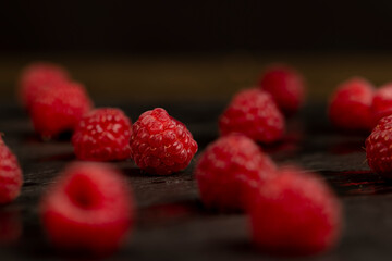 raspberries on the table, the collected amount of ripe raspberries is red, The berries are scattered on the board