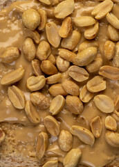 peanut butter on a piece of bread and roasted peanuts