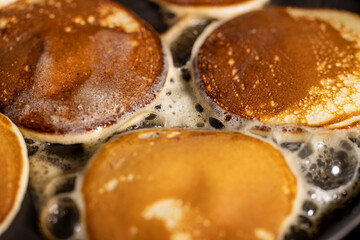 baking pancakes with butter in a frying pan, hot metal pan while cooking pancakes with butter