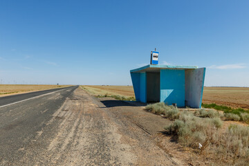 Obraz premium Bus stop along A28 road in Akzhaik District, West Kazakhstan Region under clear blue sky