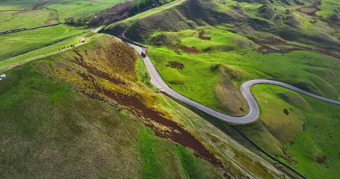 Bus driving down the bendy Road of Mam Tor landscape in Peak District - UK 